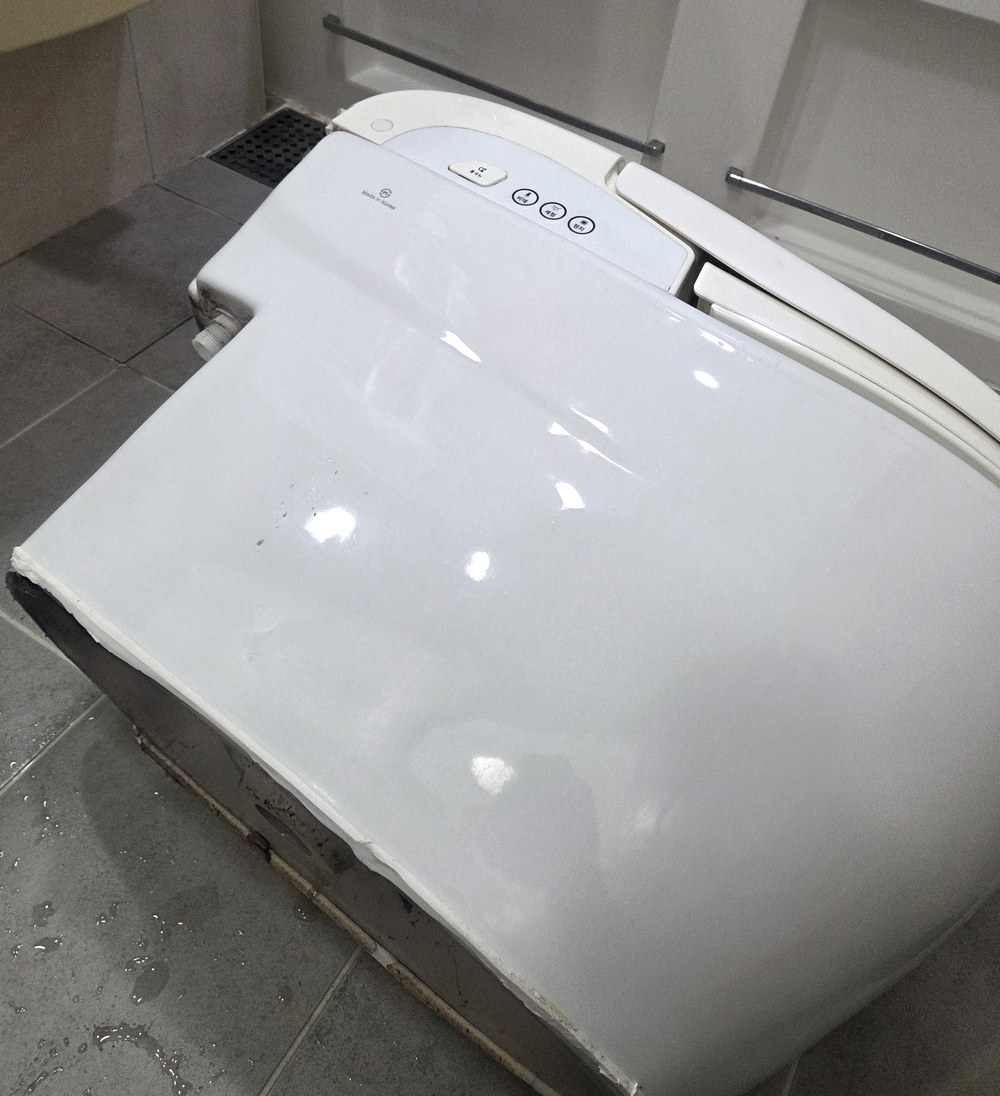 철거해 눕혀 놓은 일체형 비데 양변기