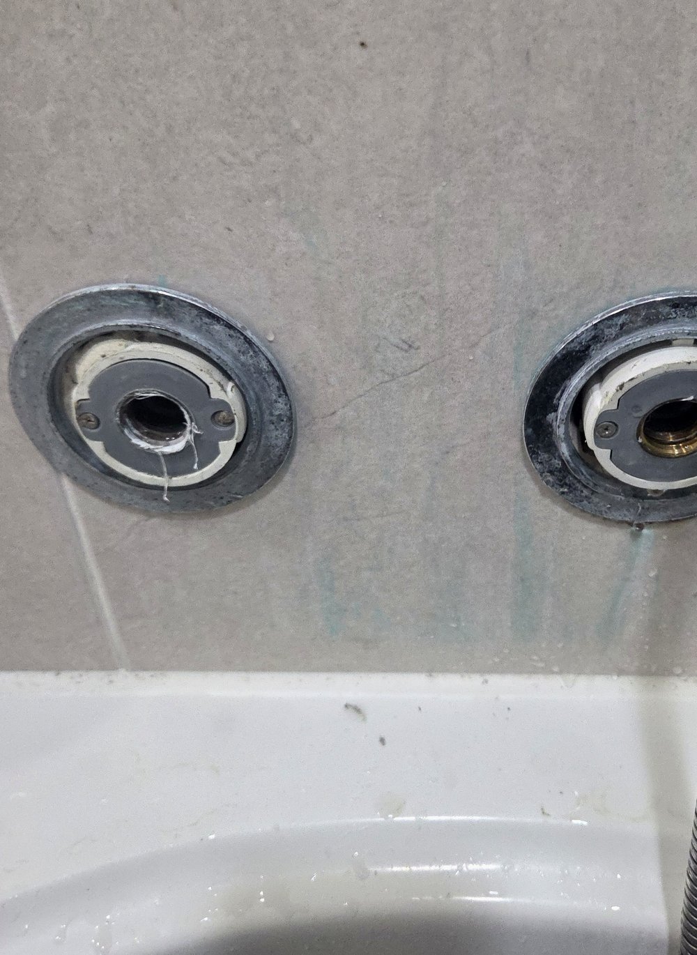편심을 빼낸 뒤 드러난 욕실 벽 소켓 두 개